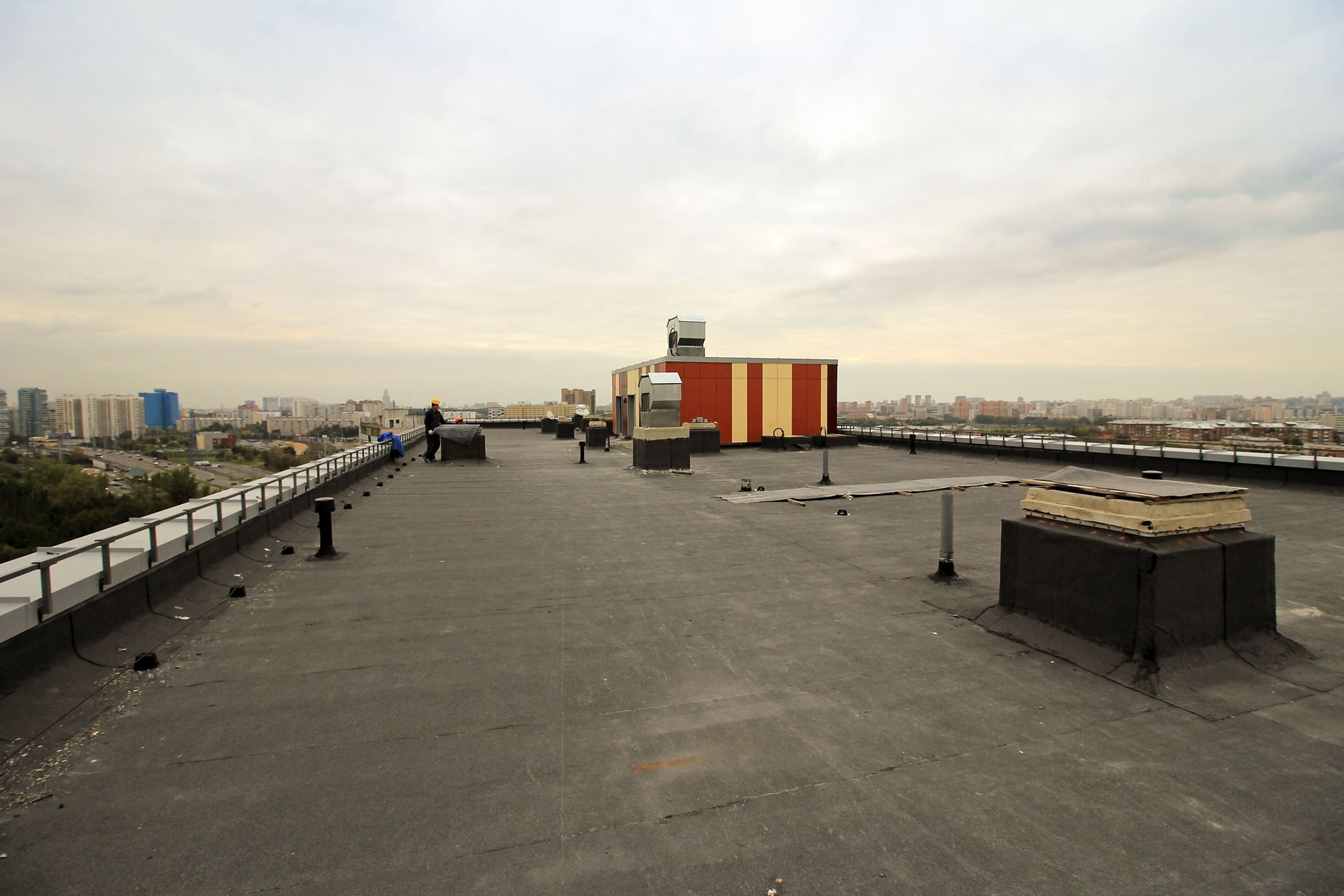 Modified bitumen hot-mop roofing installation showing layered membrane process